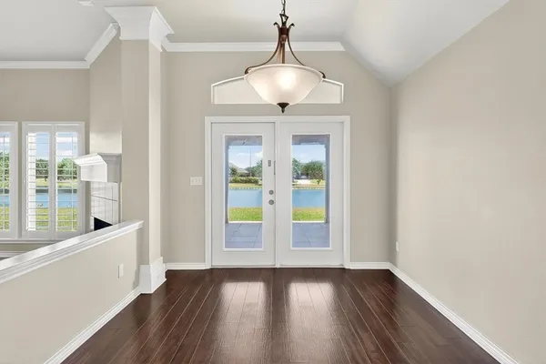 a view of an empty room with window and wooden floor