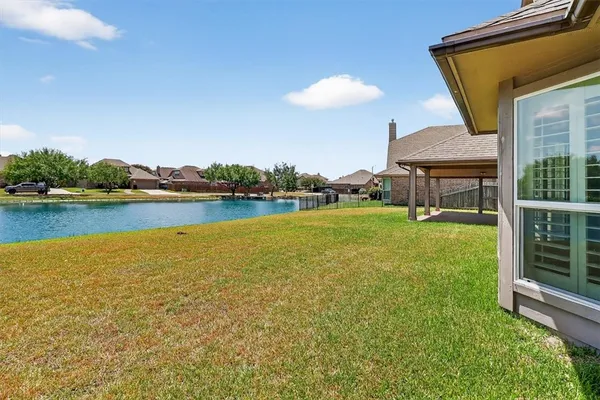 a view of a house with a yard and lake view