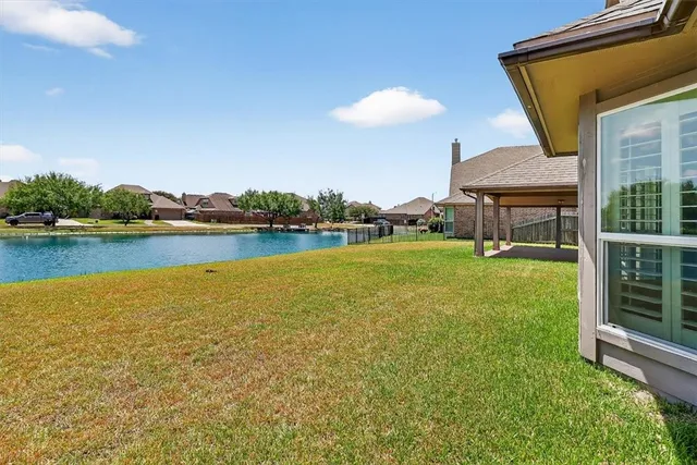 a view of a house with a yard and lake view