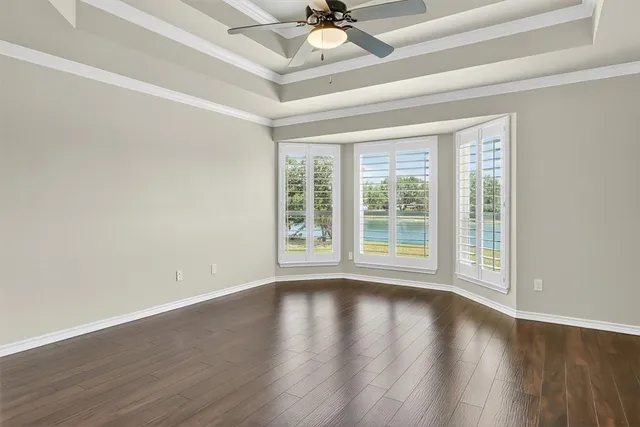 a view of wooden floor and a chandelier fan in a room