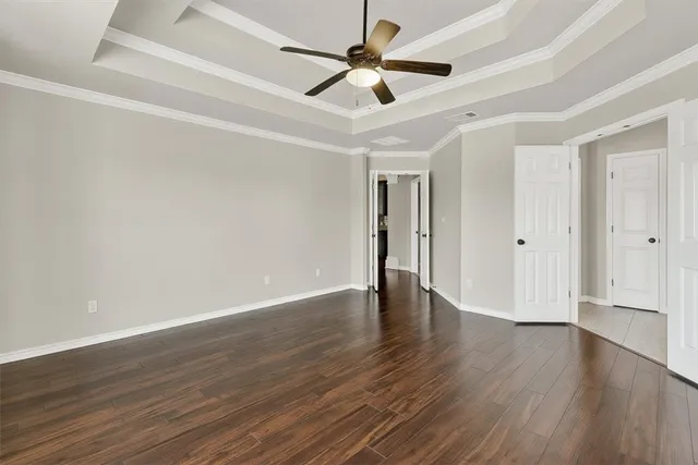 a view of an empty room with window and wooden floor