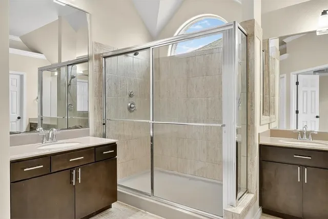 a bathroom with a double vanity sink mirror and shower