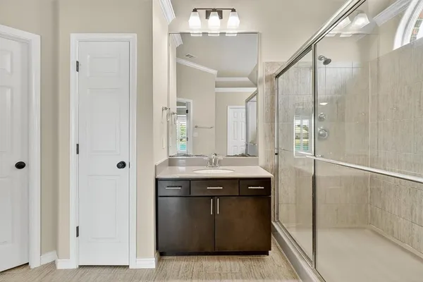 a bathroom with a granite countertop sink a mirror and a shower