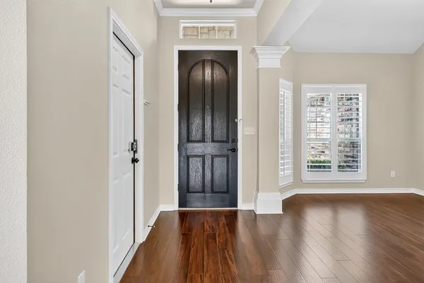 a view of a hallway with wooden floor and windows