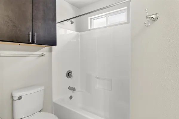 a bathroom with a shower a toilet and a sink