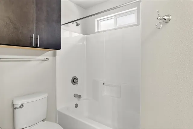 a bathroom with a shower a toilet and a sink