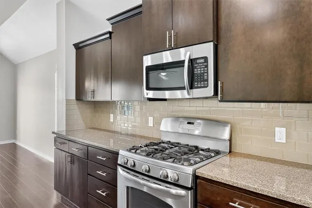 a kitchen with stainless steel appliances wooden cabinets and a stove top oven