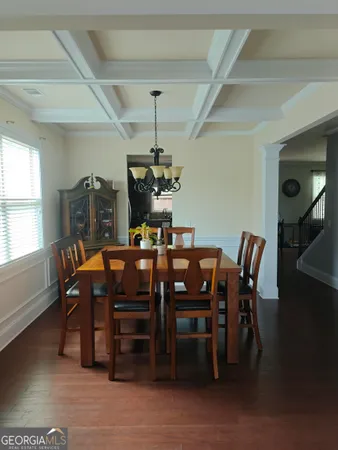 a kitchen with a dining table chairs stainless steel appliances and cabinets