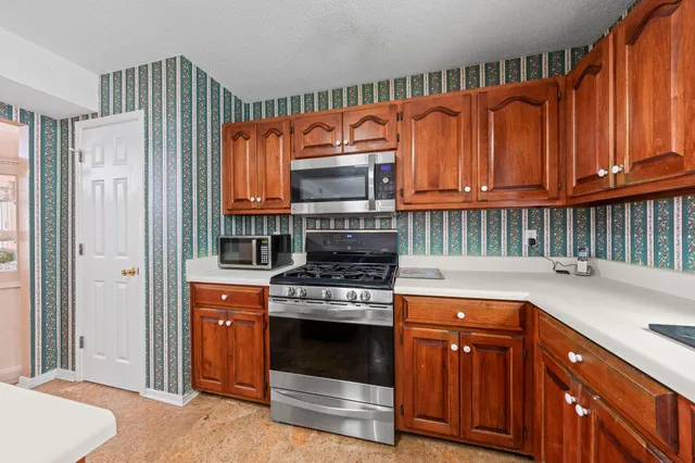 a kitchen with stainless steel appliances granite countertop a stove a sink and a refrigerator