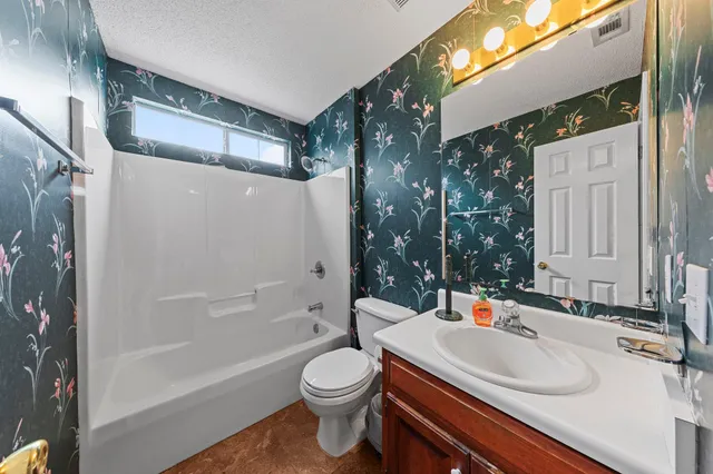 a bathroom with a sink a toilet a mirror and shower