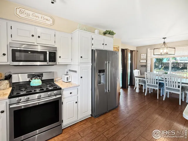 a kitchen with stainless steel appliances granite countertop a stove a refrigerator and a microwave