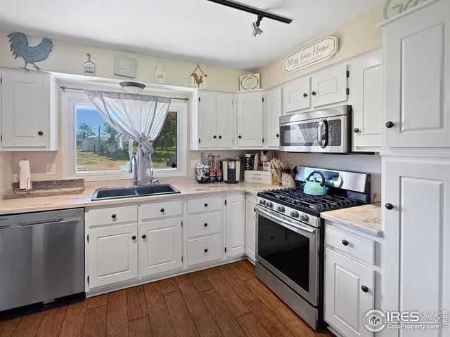a kitchen with granite countertop a stove sink and cabinets