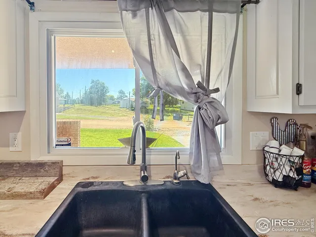 a bathroom with a granite countertop sink and a window