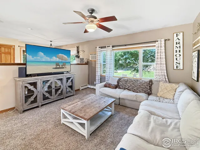 a living room with furniture a flat screen tv and a large window