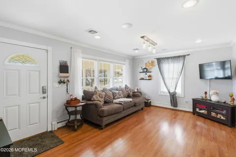 a living room with furniture and a wooden floor