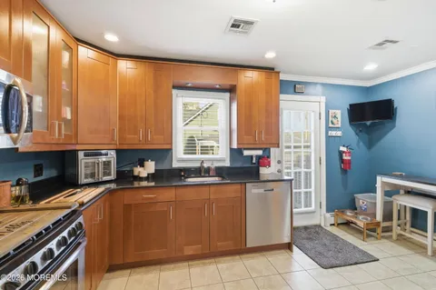 a kitchen with a sink a counter top space cabinets and stainless steel appliances