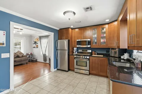 a kitchen with granite countertop a refrigerator and a stove top oven