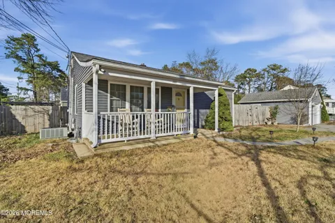 a view of a house with a porch and a yard