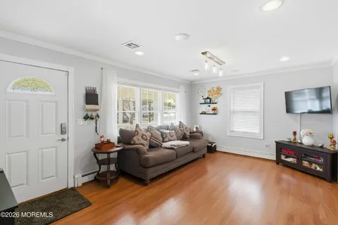 a living room with furniture and a wooden floor