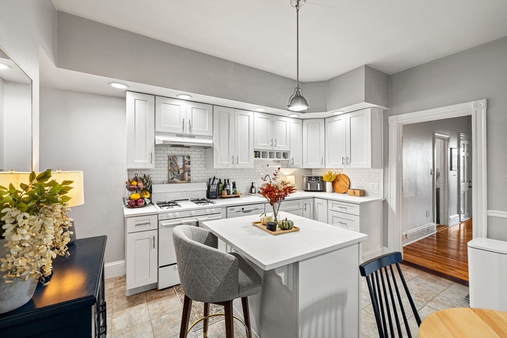 37 M Street Boston, MA 02127 - Photo 13 of 42 a kitchen with a dining table chairs sink and white cabinets