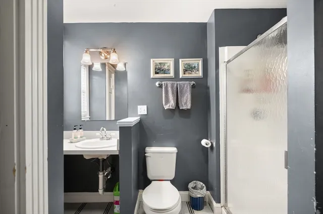 a bathroom with a toilet sink and mirror
