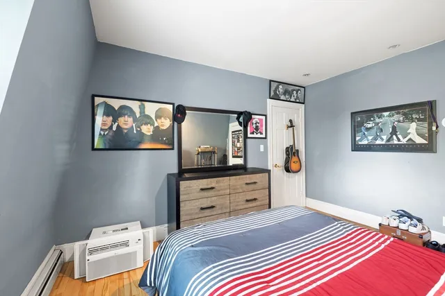 a bedroom with a bed and a tv on the dresser