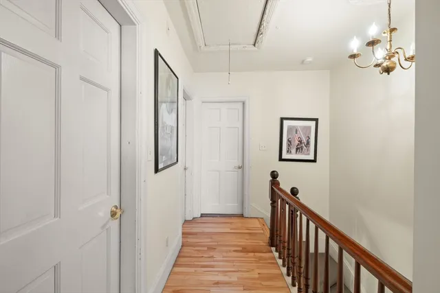 a view of a hallway with wooden floor and staircase