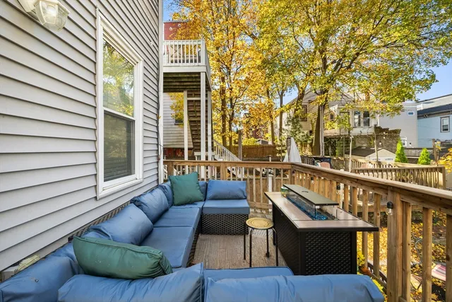 a balcony with couches and a potted plant on a table