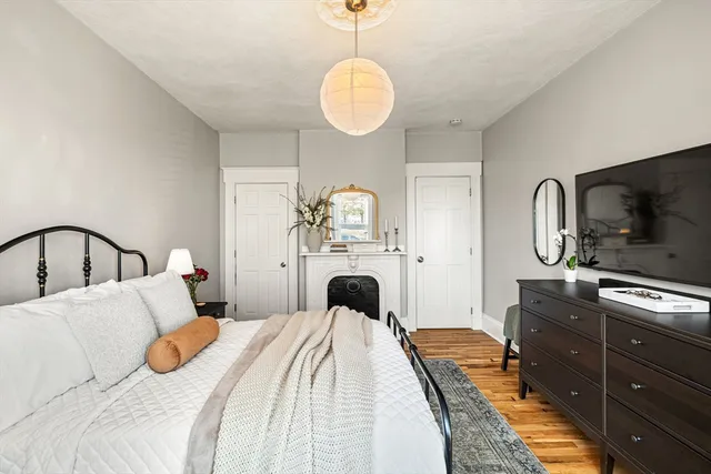 a bedroom with a bed and a flat tv screen on dresser