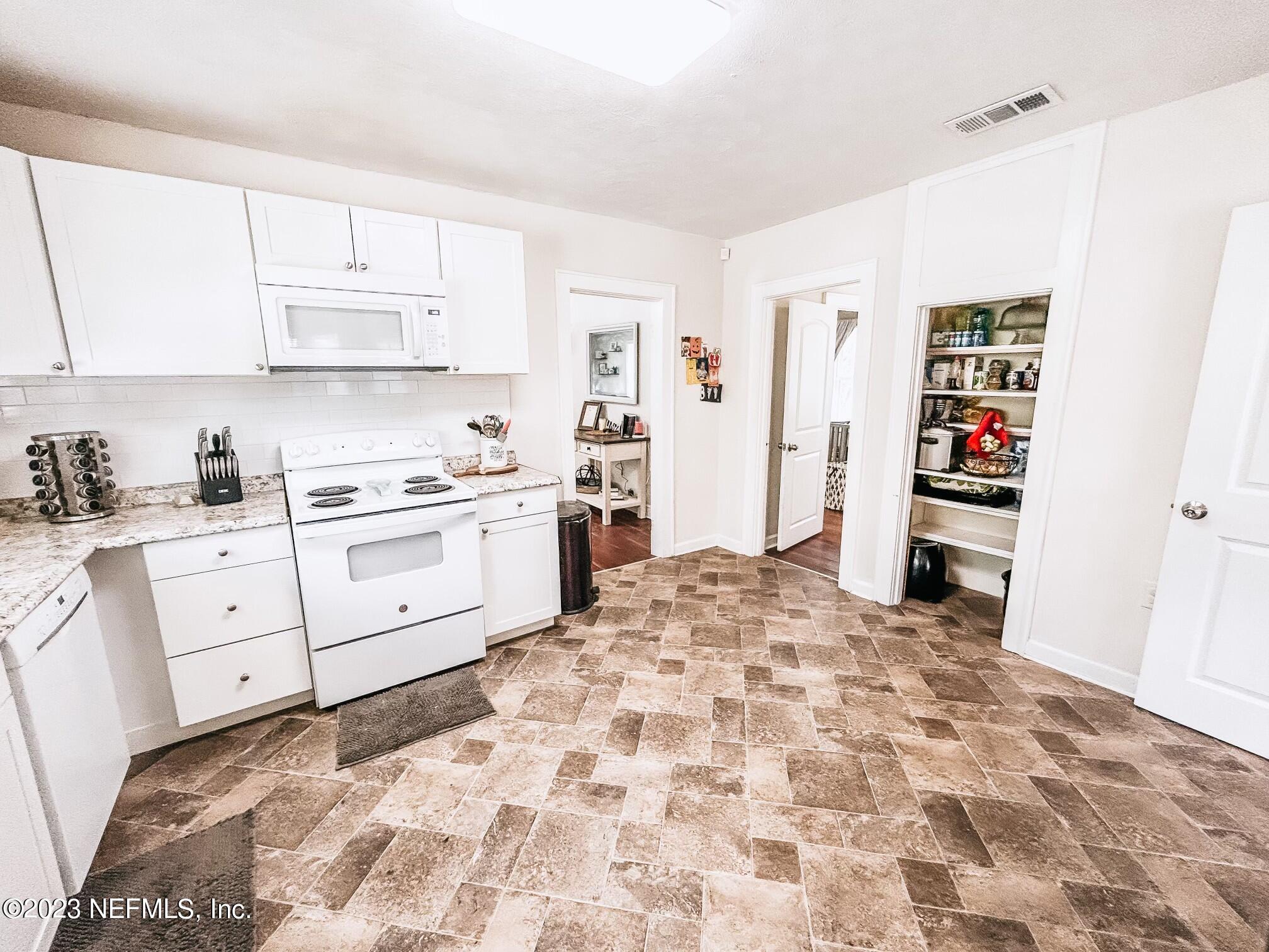 a kitchen with stainless steel appliances kitchen island sink cabinets and window