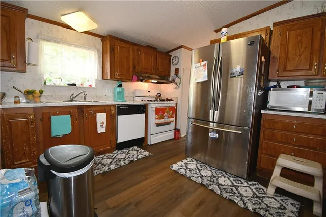 a kitchen with stainless steel appliances granite countertop a refrigerator a stove a sink and dishwasher