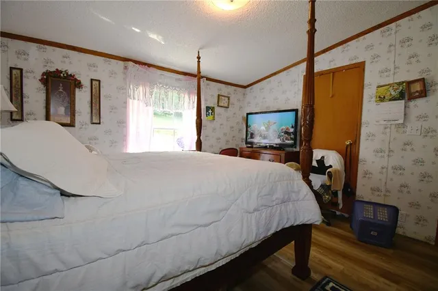a large bed sitting in a bedroom next to a window with pc on the wall