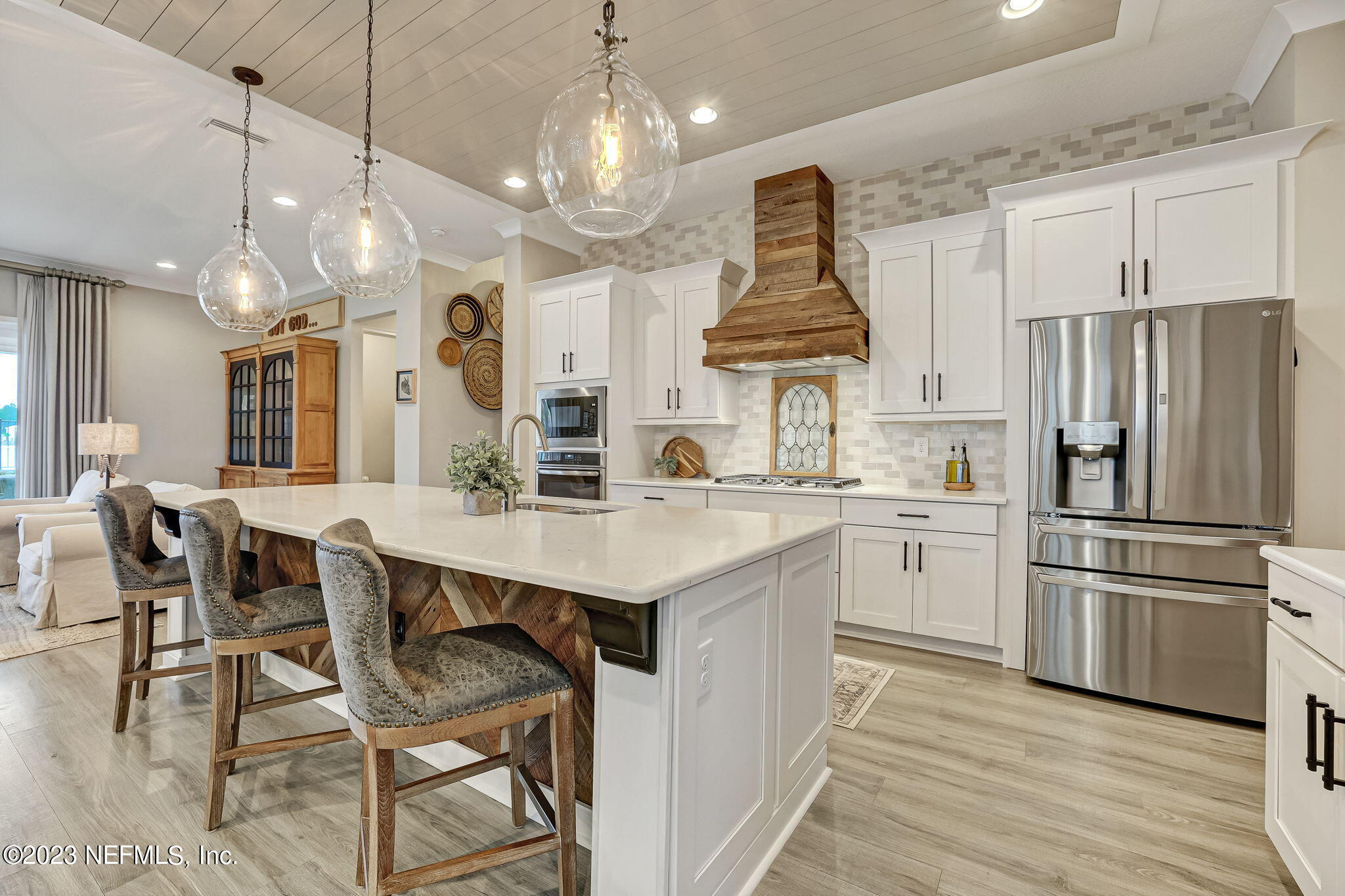 173 Rum Runner Way St. Johns, FL 32259 - Photo 19 of 104 a kitchen with stainless steel appliances kitchen island granite countertop a table chairs and a refrigerator