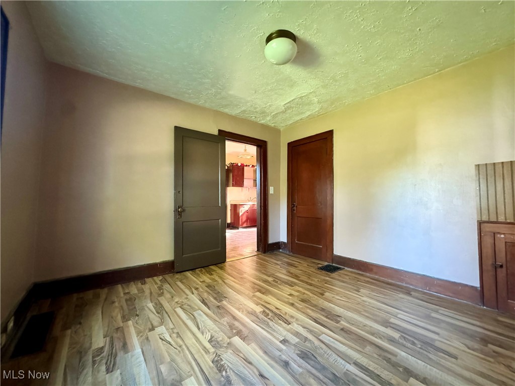 1325 Walnut Road Southeast Massillon, OH 44646 - Photo 31 of 34 Unfurnished bedroom featuring light hardwood / wood-style flooring and a textured ceiling