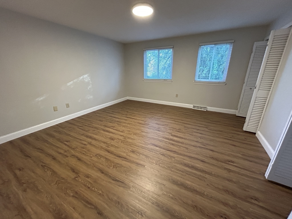 28 Apple Tree Hill Road, Unit 28 Hopkinton, MA 01748 - Photo 11 of 20 an empty room with wooden floor and windows
