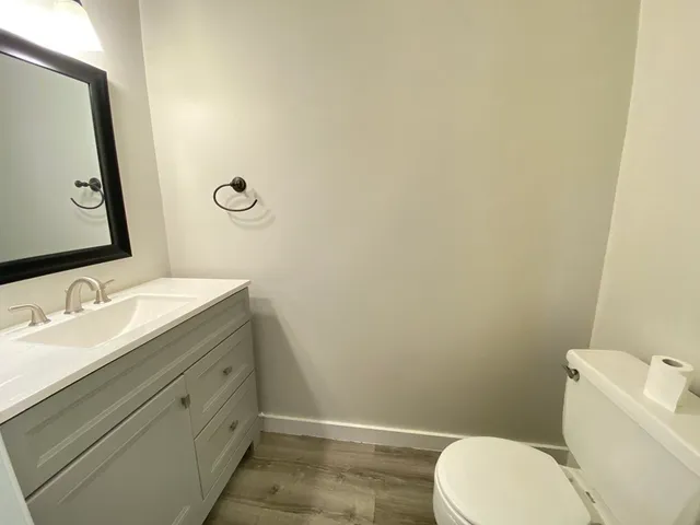 a bathroom with a granite countertop toilet sink and mirror