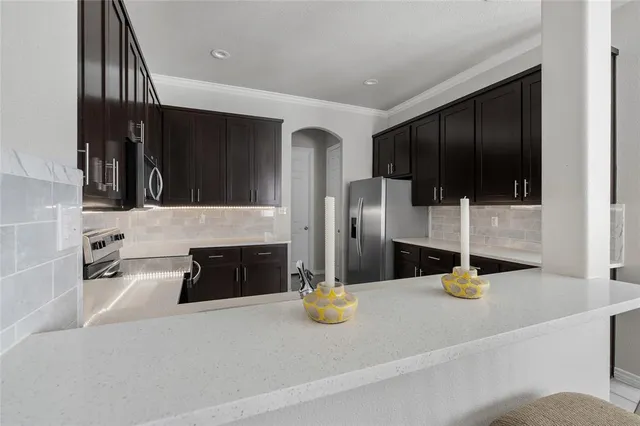 a kitchen with a refrigerator a stove and a sink with wooden floor