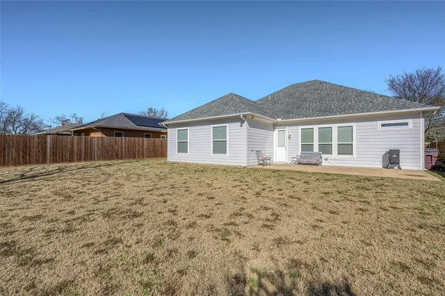 a view of a backyard with wooden fence