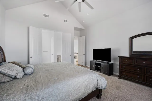 a bedroom with a bed and tv on the dresser