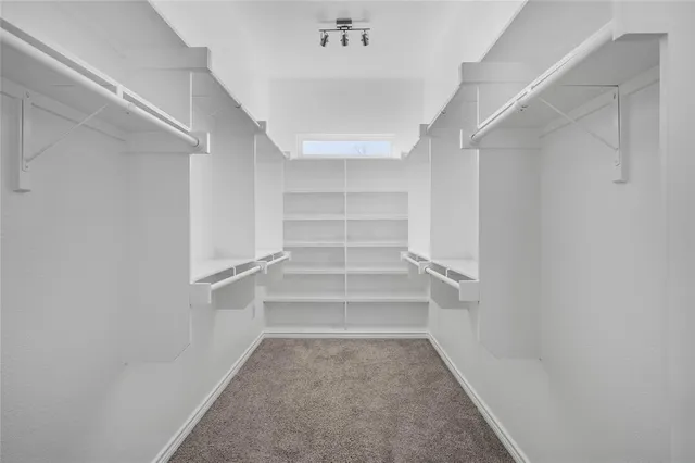 a view of walk in closet with empty racks