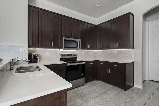 a kitchen with a sink stove and microwave