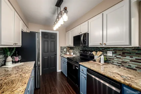 a kitchen with stainless steel appliances granite countertop a sink stove microwave and refrigerator