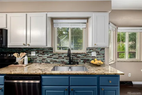 a kitchen with granite countertop kitchen island a sink a window and cabinets