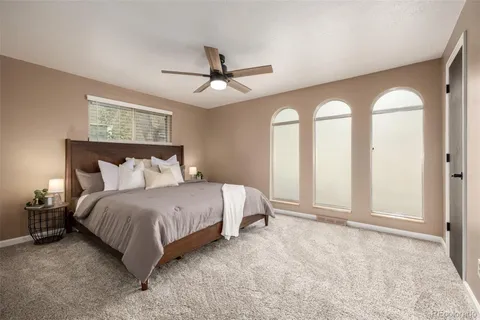 a spacious bedroom with a large bed and a chandelier