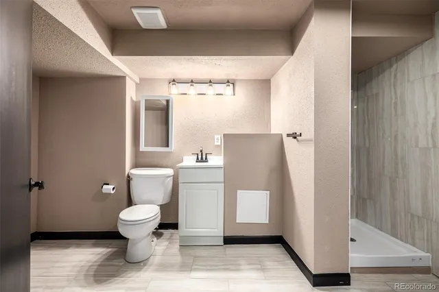 a bathroom with a toilet and a shower