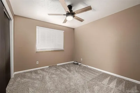 a view of a room with a ceiling fan and a window
