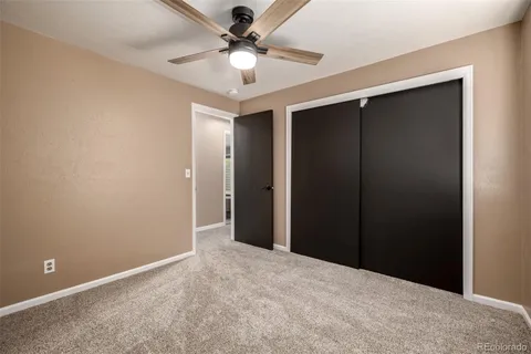 an empty room with closet and a chandelier fan