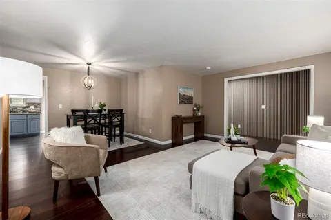 a living room with furniture and a dining table with wooden floor