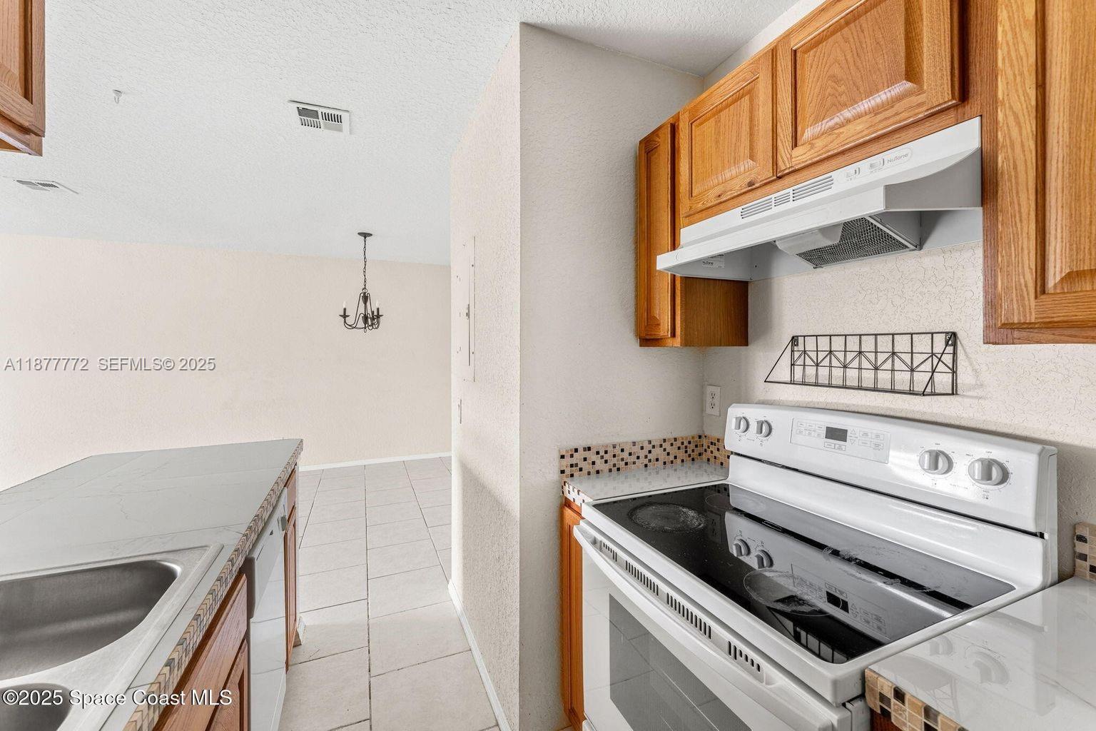 220 Columbia Drive, Unit 31 Cape Canaveral, FL 32920 - Photo 16 of 23 a kitchen with a stove and a microwave