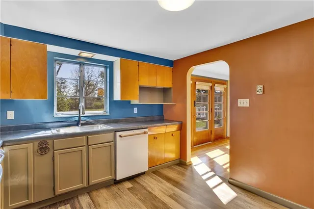 a kitchen with stainless steel appliances granite countertop a sink and cabinets with wooden floor